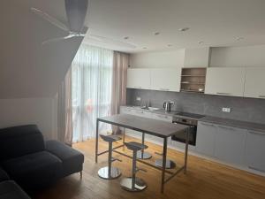 a kitchen with a table and a couch in a room at Lagoon-View Apartment Pervalka in Pervalka