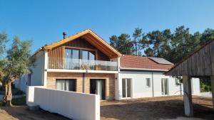 una casa con una recinzione bianca davanti di Eco Charm Discovery Quinta da Oliveirinha a Helenos