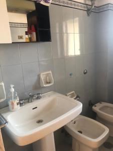 a white bathroom with a sink and a toilet at Casa Emilia in Ginosa Marina +2 photos