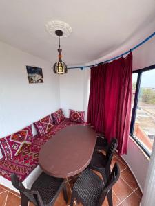 a room with a table and chairs and a couch at Le grand château Vue sur Mer uniquement les familles in Oualidia