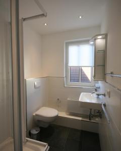 a bathroom with a toilet and a sink and a window at Brise 5 in Büsum +10 photos