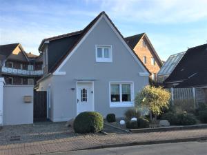 a white house with a black roof at Brise 5 in Büsum