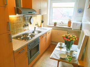 a kitchen with a sink and a stove and a table at Wattstern in Büsumer Deichhausen