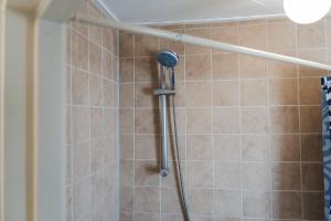 una ducha con cabezal de ducha en un baño en Gezellig 4 personen woning in Sintmaartenszee aan het strand en natuur!, en Sint Maartenszee 7 fotos más