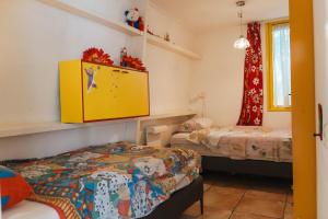 1 dormitorio con 2 camas y armario amarillo en Gezellig 4 personen woning in Sintmaartenszee aan het strand en natuur!, en Sint Maartenszee
