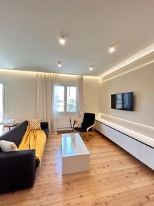 a living room with a couch and a tv at Alley Apartment in Lefkada Town