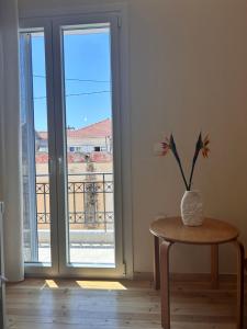 a vase with a flower sitting on a table next to a door at Alley Apartment in Lefkada Town