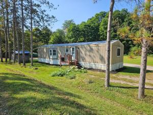 un vecchio rimorchio in un campo con alberi di Charming Countryside Retreat a Fort Plain