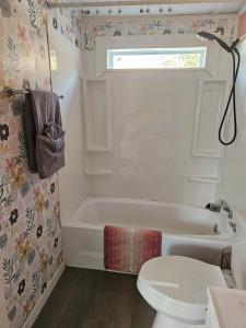 un bagno bianco con vasca e WC di Charming Countryside Retreat a Fort Plain