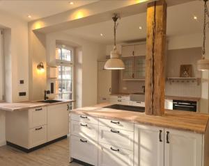 a kitchen with white cabinets and a wooden counter top at Ferienwohnung Lämmche, EG mit eingezäuntem Garten in Polling