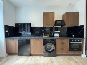 une cuisine avec une machine à laver et un lave-linge dans l'établissement Panther Carré de Soie Medipôle Astroballe, à Villeurbanne