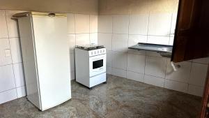 una piccola cucina con fornelli e frigorifero di Chalé de 2 quartos no Centro da Serra do Cipó a Serra do Cipo