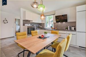 une cuisine et une salle à manger avec une table et des chaises en bois dans l'établissement Fischerdorf Ferienhaus Seeadler, à Zirchow