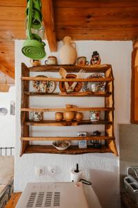 a kitchen with wooden shelves with ceramics on the wall at Villa Kamari- Stunning Views in Kritsá