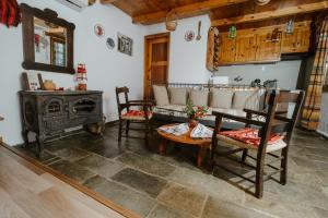 a living room with a table and chairs and a stove at Villa Kamari- Stunning Views in Kritsá +19 photos