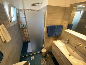 a bathroom with a shower and a sink and a tub at Sophia in Kokkari