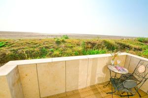 a balcony with a table and a chair and the beach at beautiful eco-beach house next to bird reserve in Snettisham