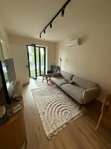 una sala de estar con un sofá y una alfombra en Andrea Apartman, en Alsóörs