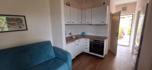 a small kitchen with a blue couch in a room at Baosići,dvije spavaće sobe in Baošići