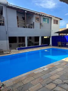 a large blue swimming pool in front of a building at Pousada Recanto do Mar in Saquarema