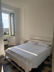 a bedroom with a large white bed with a window at Appartamento Duomo-Sempione in Milan