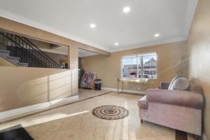 a living room with a couch and a staircase at Santa Fe Inn Los Angeles in Huntington Park