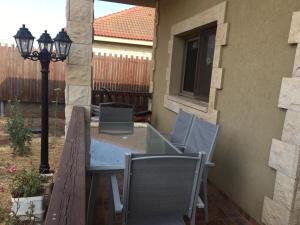 a patio with a table and chairs and a street light at שלוות חן in Qasrîne