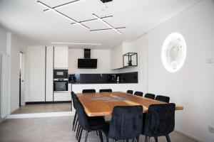 a kitchen and dining room with a wooden table and black chairs at Villa Alisha Mountain View in Casargo