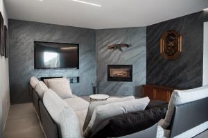 a living room with two couches and a flat screen tv at Villa Alisha Mountain View in Casargo