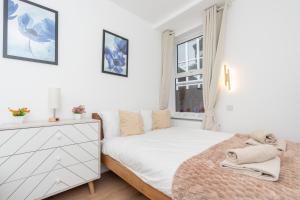 a white bedroom with a bed and a window at Open Mind Property- Stylish 3BR, HotTub & Parking in Portsmouth