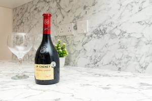 a bottle of wine sitting next to a wine glass at Open Mind Property- Stylish 3BR, HotTub & Parking in Portsmouth