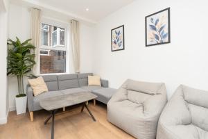 a living room with a couch and two chairs at Open Mind Property- Stylish 3BR, HotTub & Parking in Portsmouth +38 photos