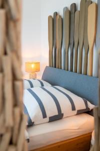 a bed with a blue and white comforter and a lamp at Seaside Corner Tossens - Seaside Corner Tossens - Komfort, Ruhe und Nachhaltigkeit in Butjadingen OT Tossens