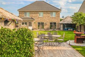 a patio with a table and chairs in front of a house at Stijl en kleur in Diest