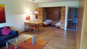a living room with a table and a dining room at Alpen-Fewo, Residenza Quadra 25 in Flims