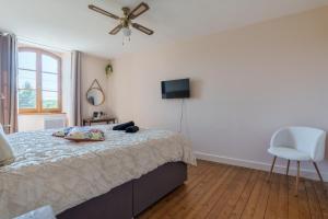 a bedroom with a bed and a ceiling fan at Maison Bö in Bossancourt