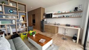 a living room with a couch and a kitchen at Piedra Azul in Playa del Carmen