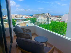 a balcony with chairs and a view of a city at Piedra Azul in Playa del Carmen