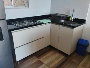 una cucina bianca con fornelli e lavello di Apartamento en Ricaurte Cundinamarca a Ricaurte