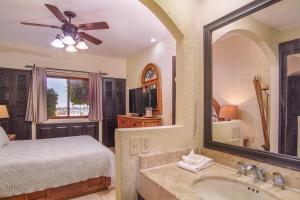 a bedroom with a bed and a sink and a mirror at Princesa De Penasco in Punta Penasco New