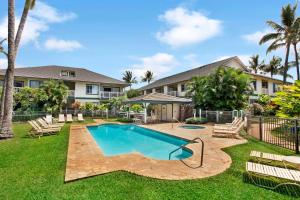 a yard with a swimming pool and a house at Regency 311 in Kipu