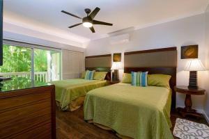 a bedroom with two beds and a ceiling fan at Regency 311 in Kipu +15 photos