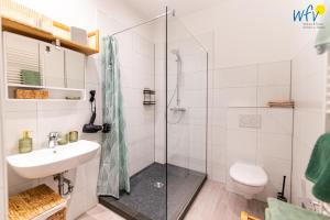 a bathroom with a shower and a sink and a toilet at Haus Hummer Köbes Ferienwohnung Paul in Juist +15 photos