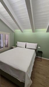 a large white bed in a room with green walls at RESIDENZA GIULIA e LIDIA - PERLA DELL'ADRIATICO in Grottammare