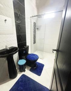 a bathroom with a blue toilet and a glass shower at Casa Stay Villa de Guaduas in Guaduas