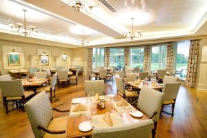 a dining room with tables and chairs and windows at 26 Muirfield Road at The Sea Pines Resort in Hilton Head Island