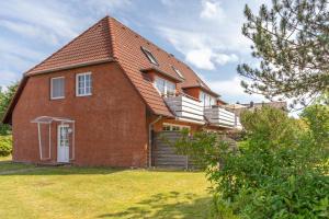 a red brick house with a porch and a balcony at Wellenklang in Böhl