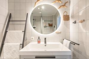a white bathroom with a sink and a mirror at Wellenklang in Böhl