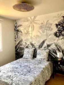 Schlafzimmer mit einem Bett und einem Wandbild von Palmen in der Unterkunft jolie maison au cœur du lot in Saint-Pierre-Lafeuille