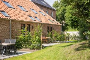 a building with a table and chairs in a yard at Van Senden 5 Anni in Krummhörn